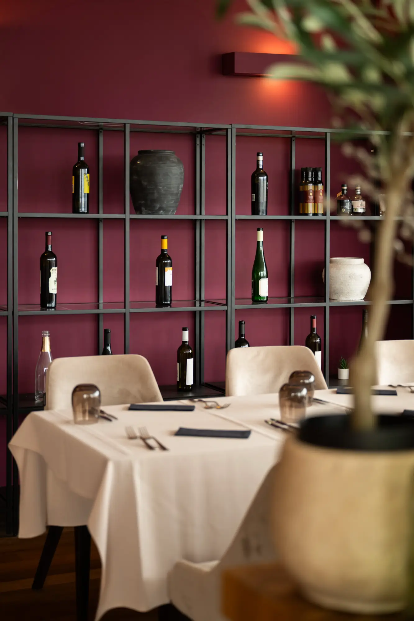 Ekskluzivni interijer restorana Eateria u Zagrebu s elegantno postavljenim stolovima, vinskim bocama na modernim policama i toplom atmosferom Cateringa Majetić.