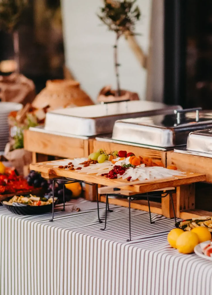 Buffet stol s toplim jelima u velikim metalnim posudama.